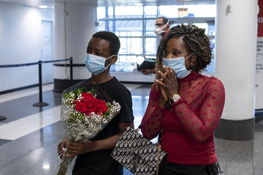 Mussa Mrisho, 12, and Mapenzi Mweniake wait at O’hare International Airport’s Terminal 5 for Mussa’s father and Mapenzi’s husband Mwenebatu Mwenemkamba, Wednesday,