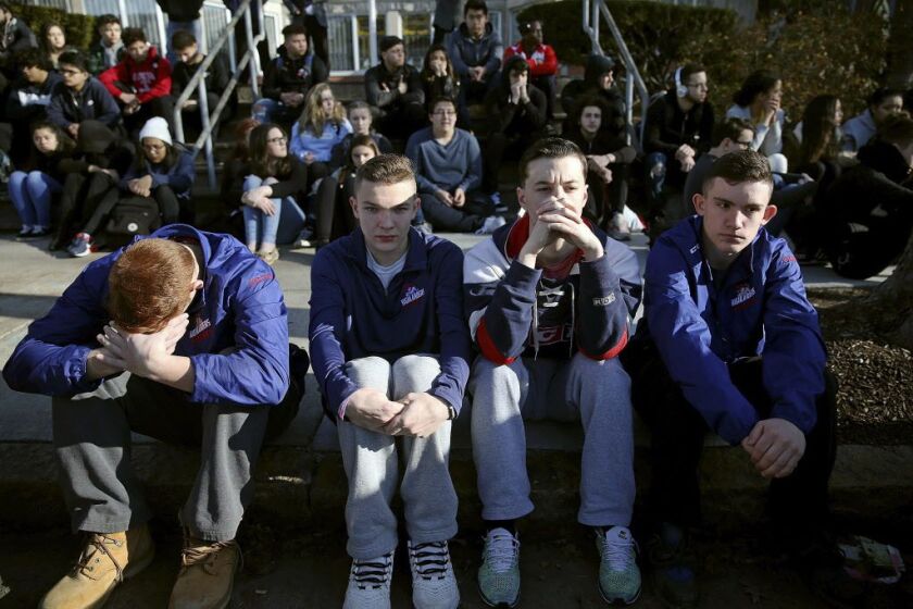 Somerville High School students sit on the sidewalk on Highland Avenue during a student walkout at the school in Somerville, Massachusetts, on Feb. 28, 2018. | Craig F. Walker/The Boston Globe via AP