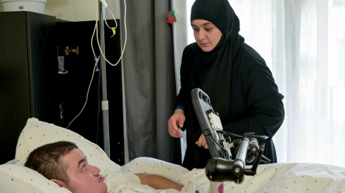 Asmaa attends to her disabled son Omar