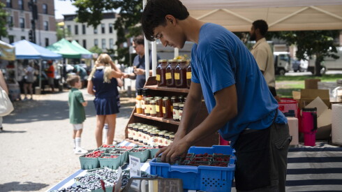 Ohlin Anderson, an employee of Ellis Family Farms, packs fruits that weren’t bought at Green City Market.