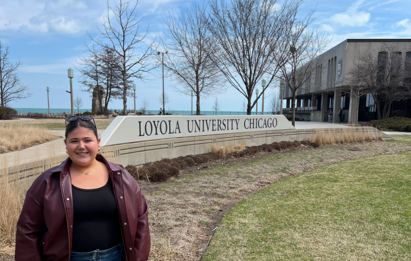 Sheridan Gorman stands next to a sign that says Loyola University Chicago.