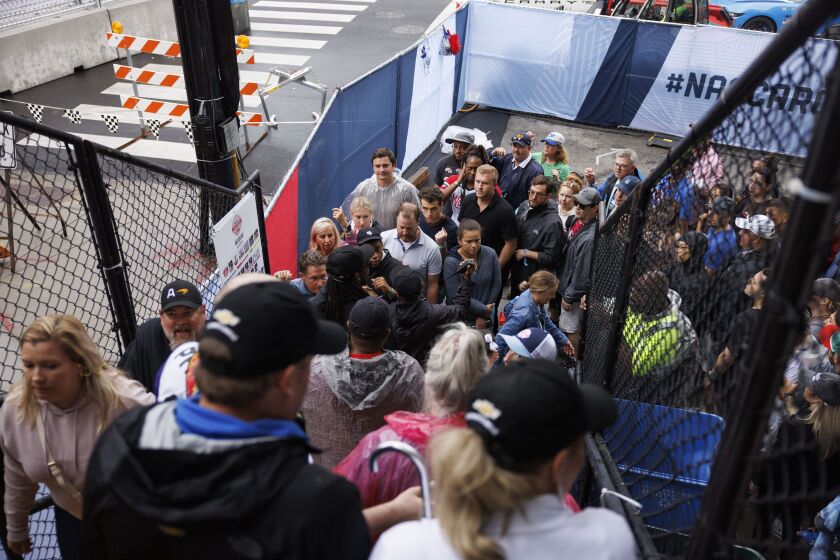 Attendees show their wrist band to gain access at one of the pedestrian bridges.