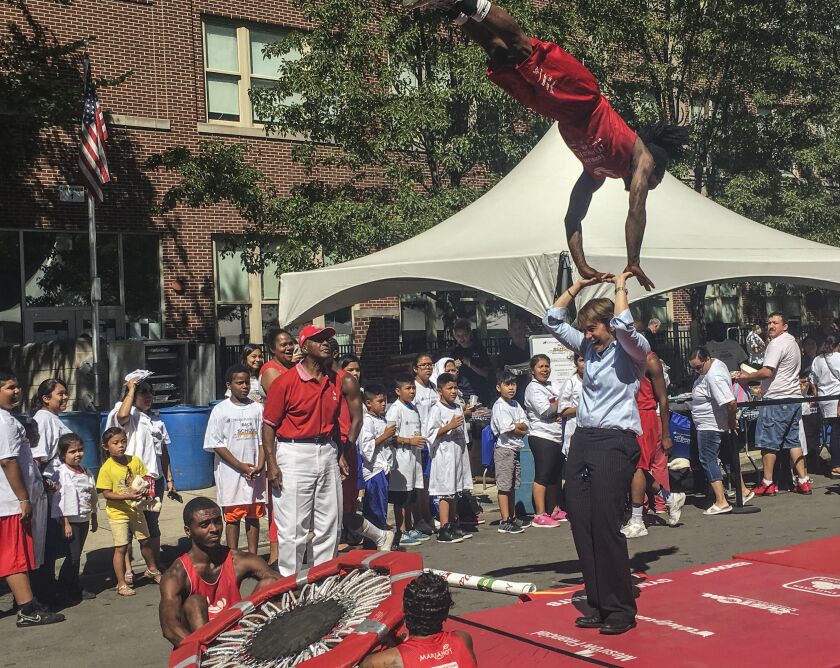 Secretary of State Jesse White (red cap) watches members of his Tumbling Team at a CPS back-to-school party in 2016.