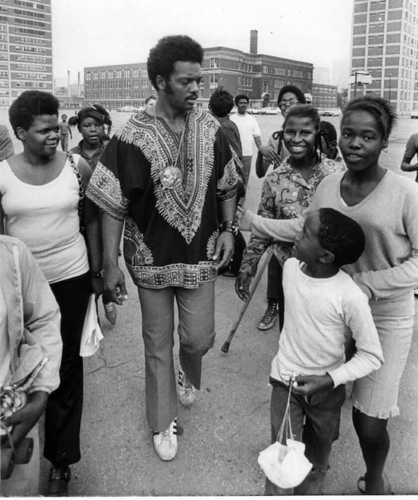 Rev. Jesse Jackson walks with people at the Cabrini-Green Housing Project in July 1970.