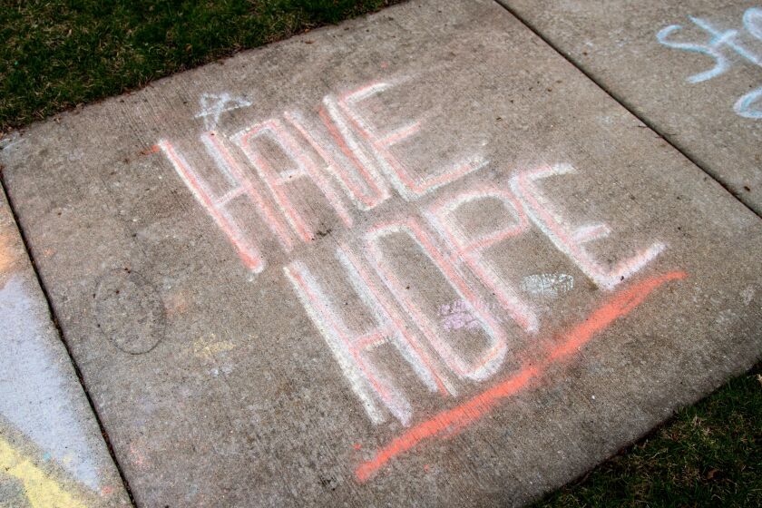 “Have Hope” is written in rain-faded chalk on the sidewalk outside a suburban Westchester home earlier this month.