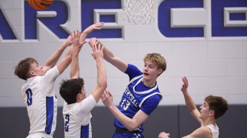 Burlington Central forward Declan Wilson (13) clears the ball past Geneva guard Dane Turner (0), Geneva point guard Gabe Jensen (2) and Geneva guard Nathan Palmer (3).