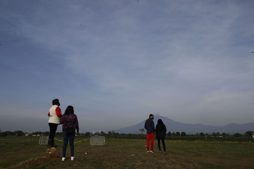 Curious onlookers try to get a glimpse of a water-filled sinkhole in Zacatepec on the outskirts of Puebla, Mexico.