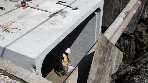 A worker walks inside a concrete water storage unit that is being installed in the 5500 block of West LeMoyne Street in Austin.