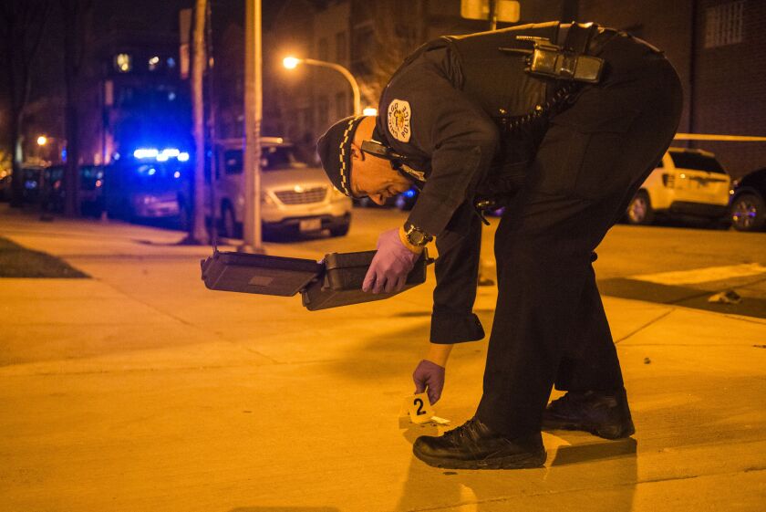An officer marks a shell casing after two men were critically wounded in a shooting Tuesday night in the Old Town neighborhood. | Tyler LaRiviere/Sun-Times