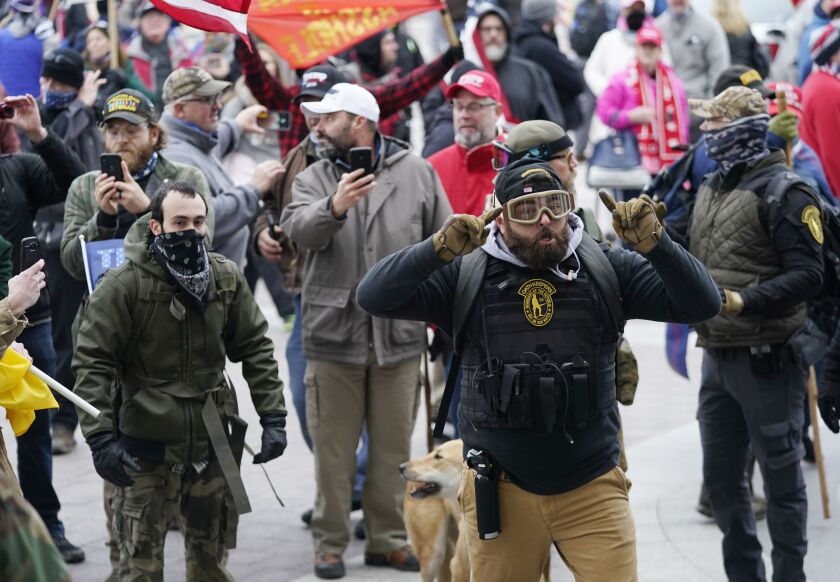 FILE - Trump supporters use their cell phones to record events as they gather outside the Capitol, Jan. 6, 2021, in Washington as Congress prepares to affirm President-elect Joe Biden’s victory.