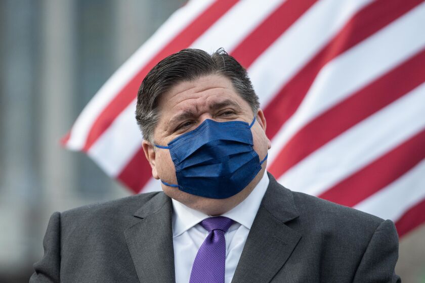 Gov. J.B. Pritzker listens during a news conference about the opening of the new COVID-19 mass vaccination site on the parking lot of the United Center in the Near West Side neighborhood last week.