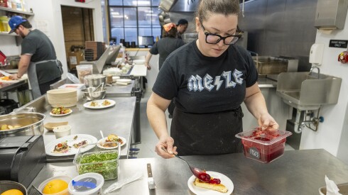 Elizabeth Gartelos Morris, co-owner and chef at Meze Table, puts toppings on a feta cheesecake at Thattu in Avondale during Monday Night Foodball on Monday.
