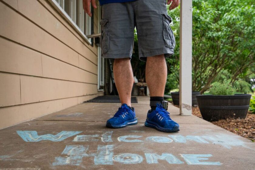Cesar Elizarraraz stands with a welcome message on the front porch of his home in Crystal Lake. Though reunited with his family, his case is far from over.