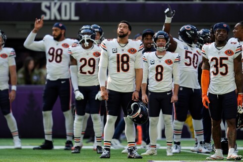 Bears quarterback Caleb Williams (18) stands on the field with teammates before a game against the Minnesota Vikings, Sunday, Nov. 16, 2025, in Minneapolis.