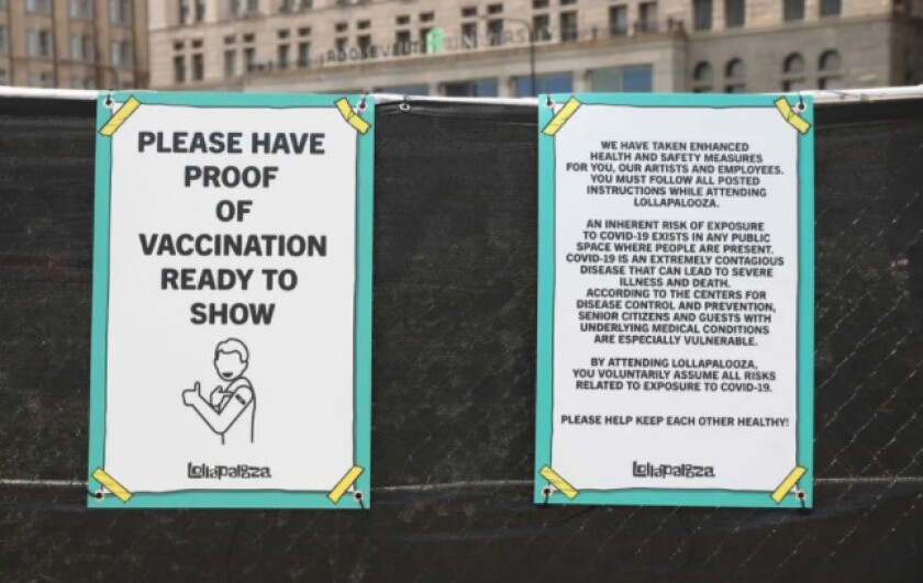 Signs posted at an entrance to Lollapalooza alert attendees that they voluntarily assume all risks related to COVID exposure. Ashlee Rezin/Sun-Times