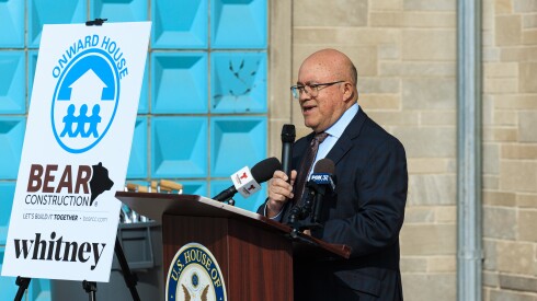 Onward Neighborhood House Executive Director Mario Garcia speaks from behind a podium.