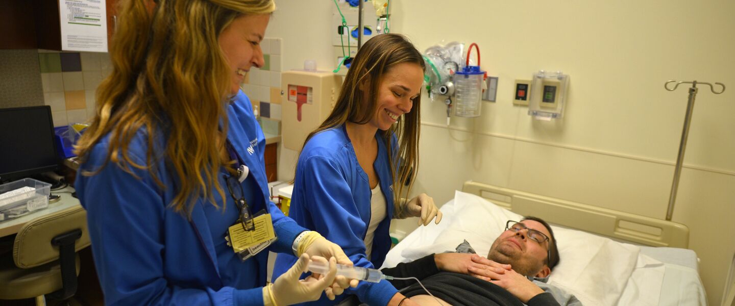 Oncology nurses Katie Leinenweber (left) and Caroline Castino fill Sean O’Reilly’s hepatic artery infusion pump. The technology, decades old, is finding new use at Northwestern Memorial Hospital.