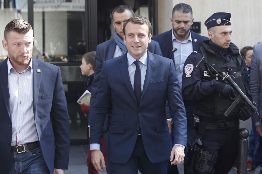 French centrist presidential candidate Emmanuel Macron, (center) leaves his Paris apartment Monday. | Thibault Camus/Associated Press