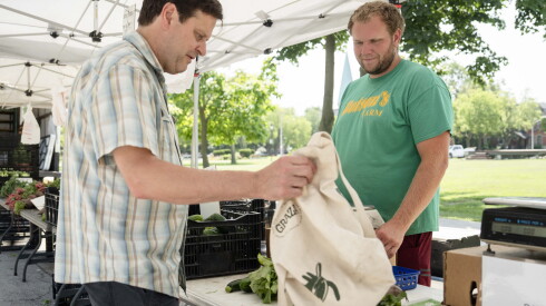 A customer buys produce from James Dotson of Dotson’s Farm at Pullman Farmers Market in Pullman, Wednesday, July 15, 2026.