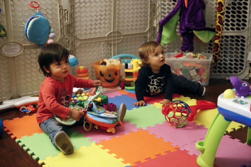 In this Jan. 23, 2018 file photo, sixteen-month-old Ethan Dvash-Banks, left, and his twin brother, Aiden, play in the living room of their apartment in Los Angeles. (AP Photo/Jae C. Hong, File)