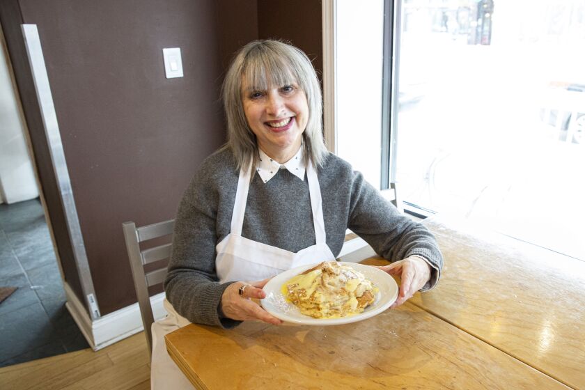 Owner Lisa Santos with her bread-pudding pancakes with vanilla anglaise sauce at Southport Grocery and Cafe.