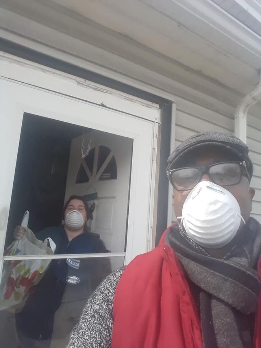 Deborah Watson receives a care package from Deyon Dean, a volunteer delivery driver for the “Senior Relief Project” started by businessman Early Walker, owner of W&W Towing.
