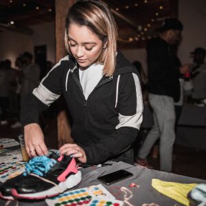 A volunteer helps clean shoes at Kicks 4 The City’s 2018 shoe drive.