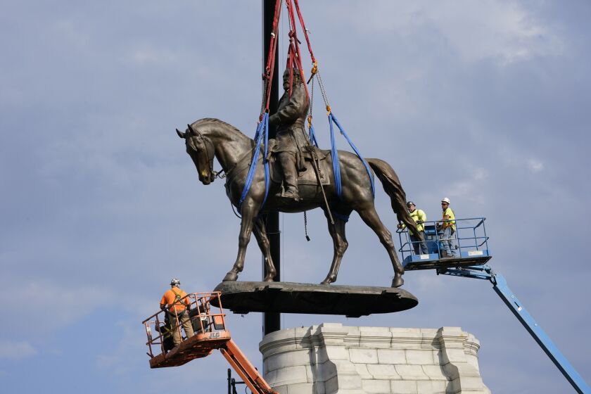 Crews work Wednesday to remove one of the country’s largest remaining monuments to the Confederacy, a towering statue of Confederate General Robert E. Lee on Monument Avenue in Richmond, Va.