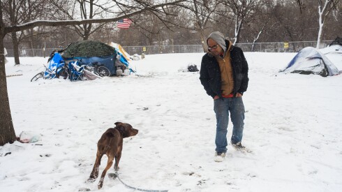 Leonilo Laude, 39, tries to calm a dog belonging to one of the neighboring tents at an encampment near West Admore Avenue at Legion Park in North Park, Monday, March 16, 2026. | Anthony Vazquez/Sun-Times