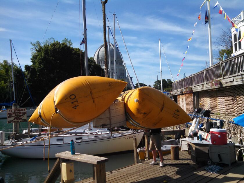 Katie Traub operated the lift at Wilmette Harbor after the anchor for a new weather was wrapped in lift bags; then placed in the water.<br>Credit: Dale Bowman