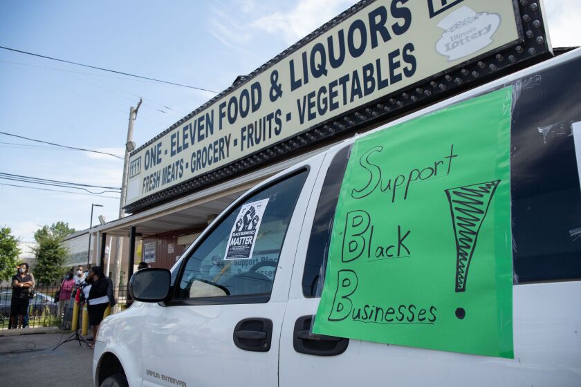 A sign that reads “Support Black businesses!” is taped on a car outside One-Eleven Food and Liquors in East Garfield Park during a press conference where community advocates and residents demanded that the store’s license be re-instated Thursday morning, Aug. 13, 2020. The store’s license was revoked because the owner allegedly failed to stop loiterers, operate within permitted hours and hire security guards, which the owner’s relatives and advocates deny.