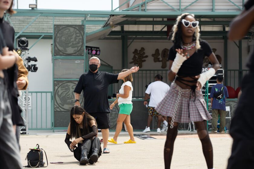 A spectator tries to learn a K-pop dance as K-pop fans participate in K-pop Random Dance, where people jump into a circle to dance together whenever they hear a song they know the choreography of, during “Youth of Chinatown,” a three-day event featuring hip-hop and K-pop performances at Chinatown Square Plaza, Saturday, Aug. 27, 2022.