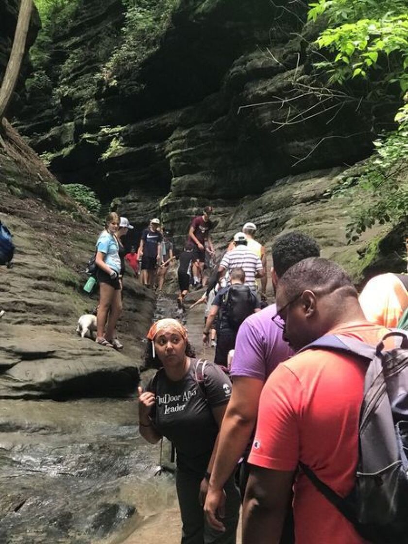 A group of around ten hikers climb up into a canyon