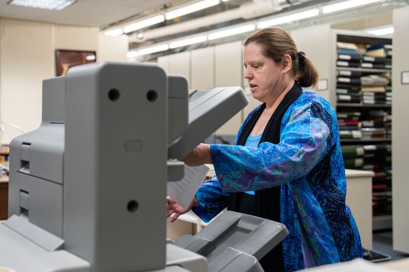 CSO librarian Carole Keller prints out orchestral parts of a score that has been sent electronically for use by the symphony. The machine also staples and folds the parts for each musician.