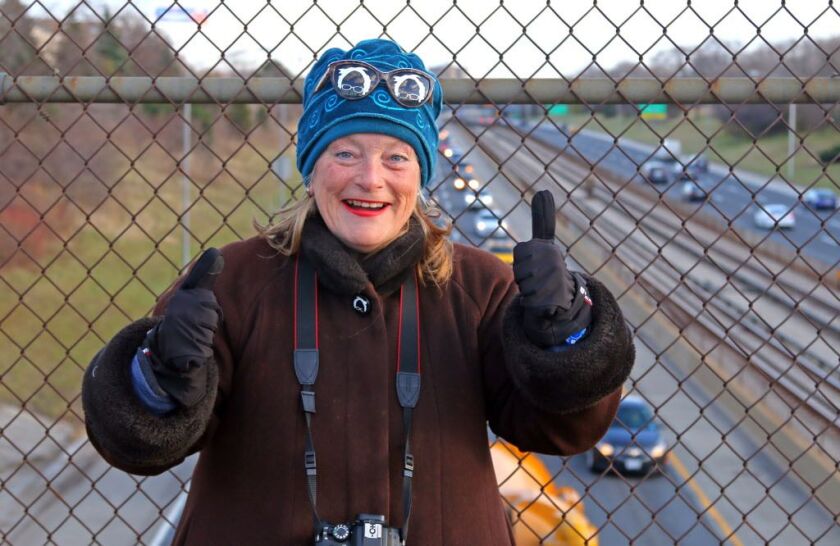 Veronica Wolski gestures to drivers as she protests with banners on a Kennedy expressway overpass.