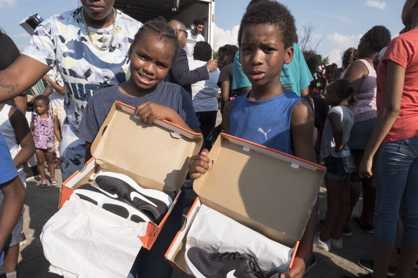 Pershais Comer, 9, and Cameron Comer, 8, posing with their new shoes they got from Vic Mensas foundation, Save Money Save Lifes shoe give away event. | Rick Majewski/For the Sun-Times