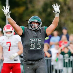 Glenbard West’s Andrew Johnson (65) celebrates after Nic Seifert (24) scores the game-winning touchdown against Hinsdale Central.