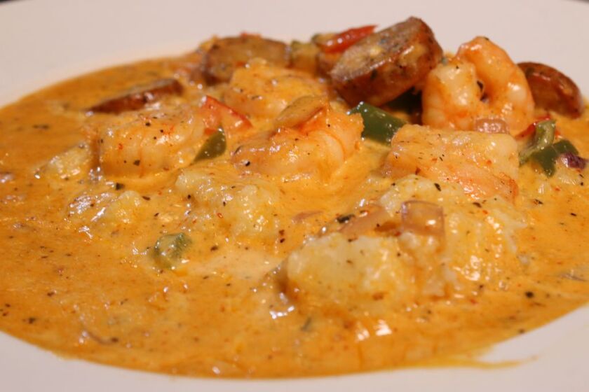 The shrimp and grits, served at Hidden Manna Cafe, is made with creamy grits topped with red and green pepper, garlic, onion in our home made shrimp and spicy chicken andouille sausage sauce. 