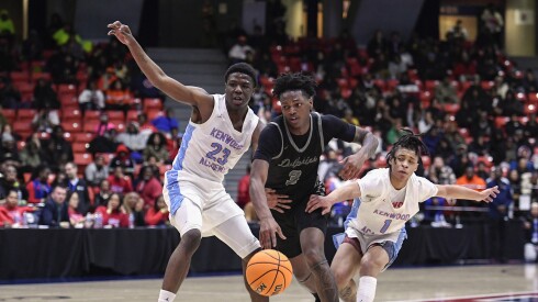 Young’s Marquis Clark (3) moves the ball against Kenwood’s TJ Seals (23) and Amari Edwards (1).