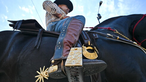 A close-up view shows a rider's boot and stirrup featuring Louis Vuitton engravings during the 55th Annual 26th Street Mexican Independence Day Parade.