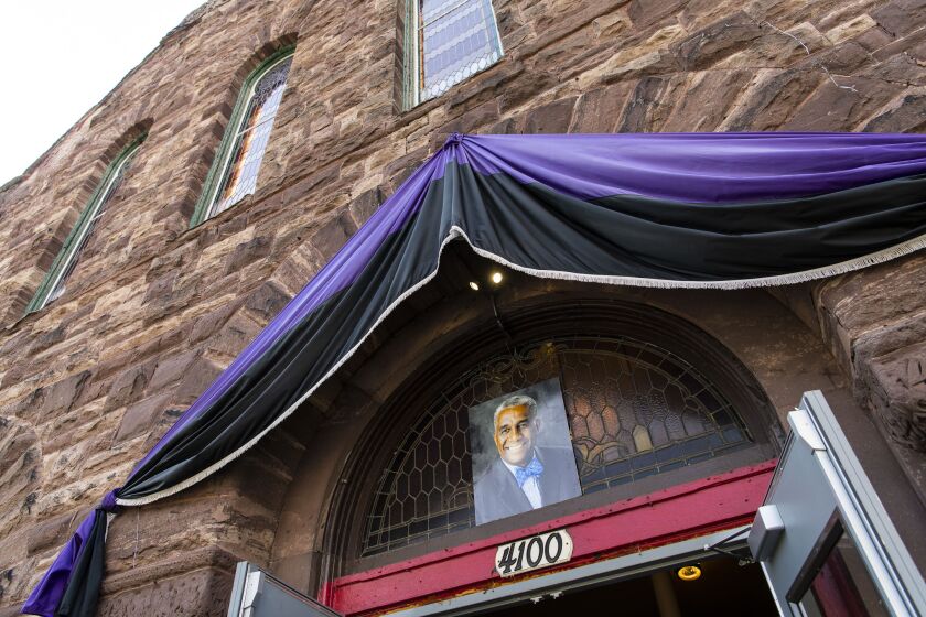 Rev. Leon Finney’s photo and bunting hangs above the Metropolitan Church in the Bronzeville neighborhood as his body lies in state inside, Friday.