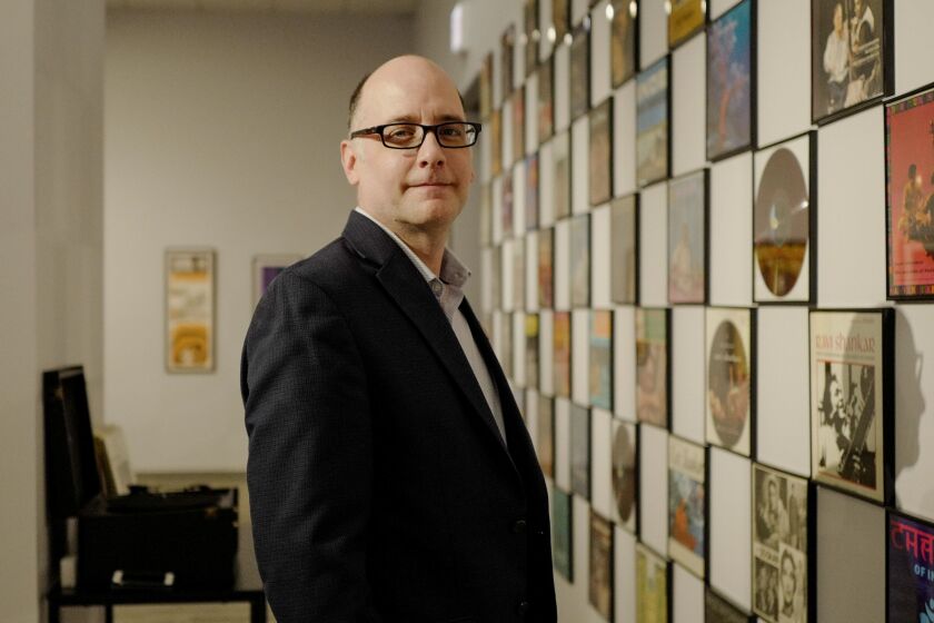 Brian Keigher, co-curator of “Ravi Shankar: Ragmala to Rockstar,” stands alongside a collection of Shankar’s vinyls during a media preview of the retrospective of Shankar at the South Asia Institute in the South Loop.