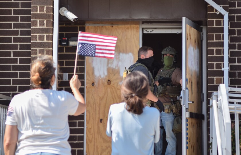 Protesters shout at federal immigration agents at the front door of the Broadview ICE facility Sunday, Sept. 21, 2025.