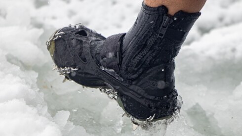 George Miller wears crampons on his boots as he wades out into an icy Lake Michigan at Oak Street Beach, Sunday, Jan. 25, 2026. | Candace Dane Chambers/Sun-Times.