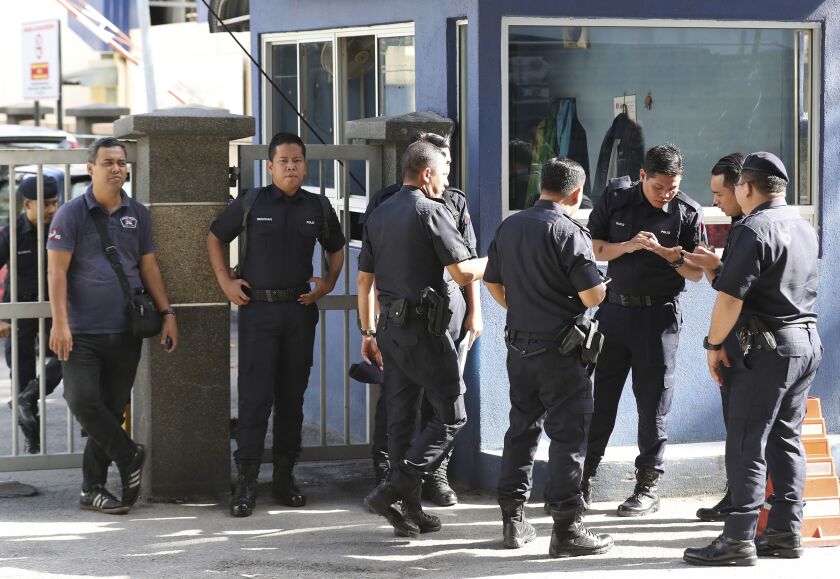 Police officers stand near the entrance of the forensic department at the hospital in Kuala Lumpur, Malaysia on Thursday. Kim Jong Nam, the half brother of North Korean leader Kim Jong Un, was assassinated Monday at an airport in Kuala Lumpur, telling med