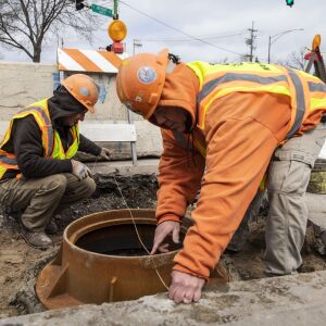 Department of Water Management laborer Glenn Kubek uses a string to check that the catch basin being installed at 93rd and Jeffery is a quarter inch below the street, so it will drain properly, Wednesday morning, April 27, 2022. He said that even 1/8th of an inch would do because of sinkage caused by passing traffic.