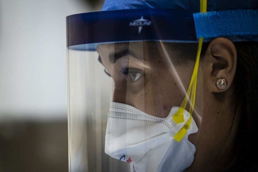 Nurse practitioner Capri Reese talks to a patient while a doctor administers an IV at Roseland Community Hospital on the Far South Side, Tuesday afternoon, April 28, 2020. During Reese’s standard 12-hour shift Tuesday, she responded to five code blues and three patients suffering from COVID-19 died.
