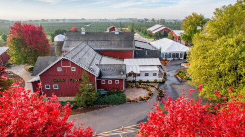 Overhead shot of a red barn surrounded by colorful fall foliage