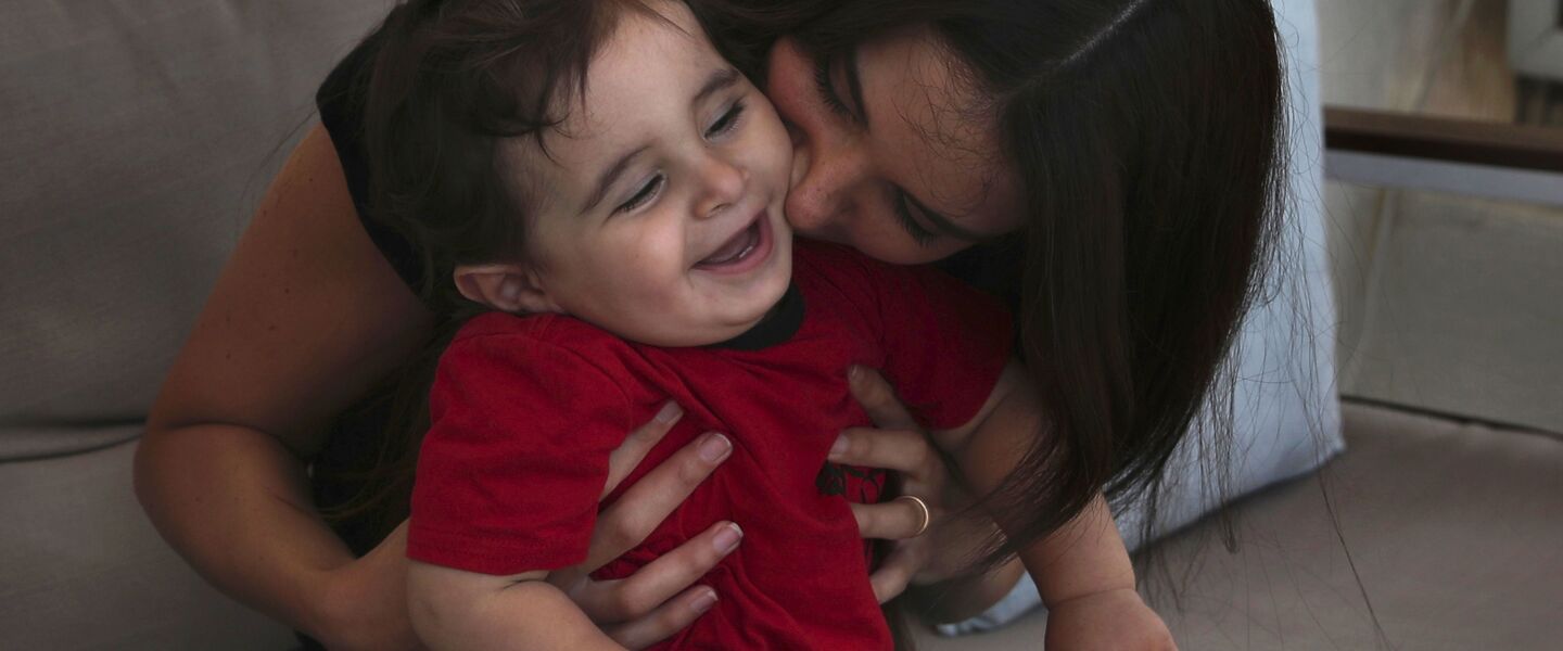 Emmanuelle Khnaisser kisses her 1-year-old sonGeorges Khnaisser at their home in Jal el-Dib, north of Beirut, Lebanon. Khnaisser was in the final stages of labor when last year’s massive Beirut blast tore through the hospital, smashing windows, doors and machines in the operations room and riddling her lower body with tiny pieces of glass.