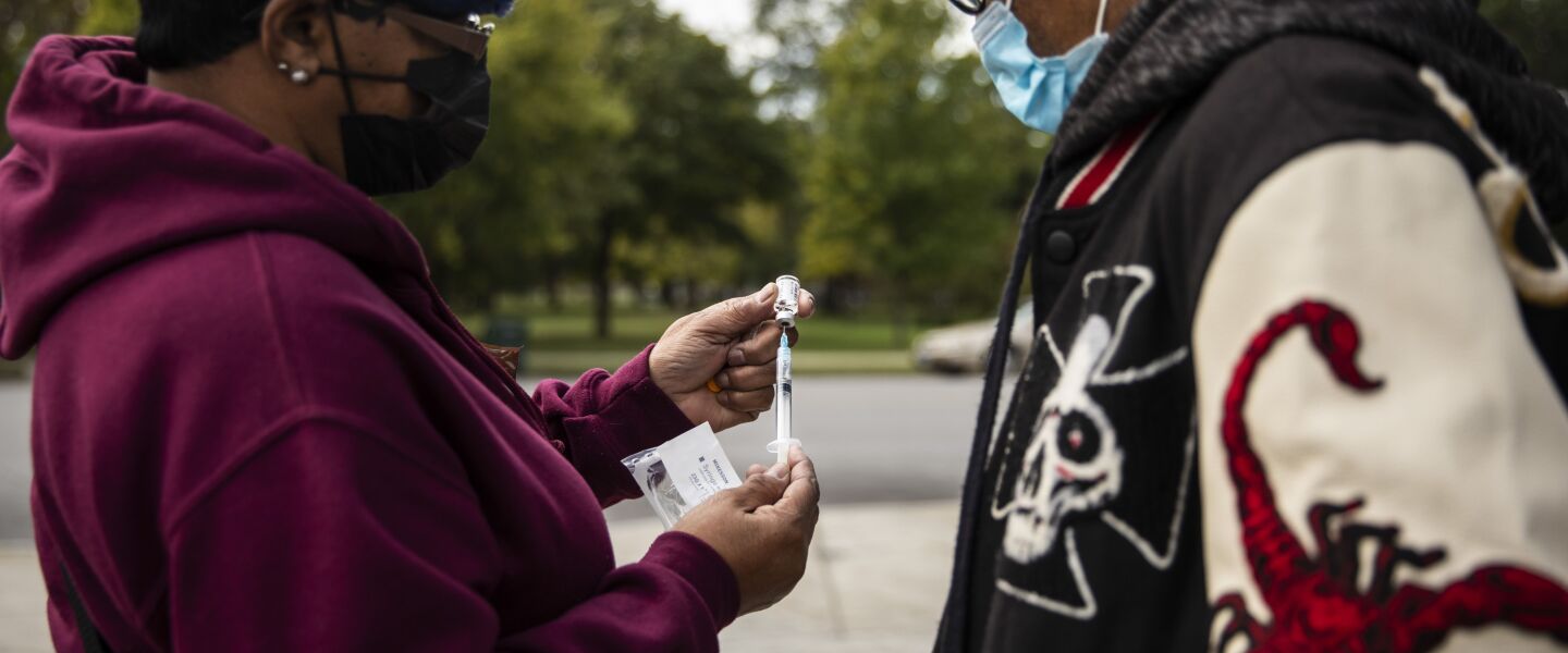 Rochelle Wade, with the drug addiction recovery agency Thresholds, shows a man how to use naloxone to reverse a heroin overdose.